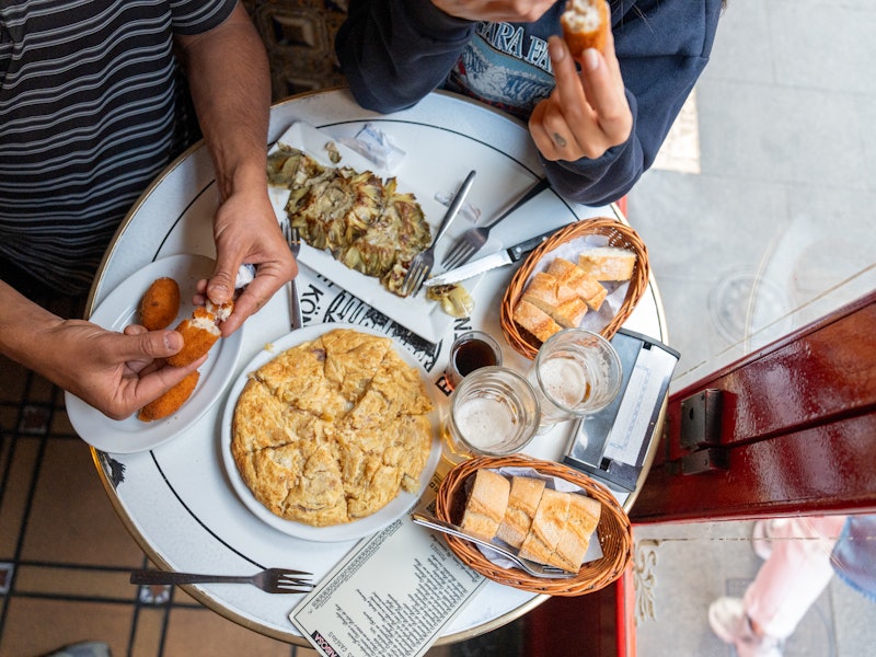 Facundo Yair and his girlfriend, Carlota Urdiales, ordering tapas and beer at Bodega de La Ardosa.